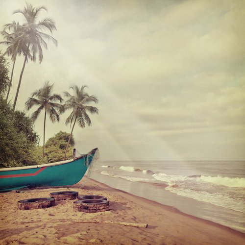 vintage photo with bright blue canoe on beach